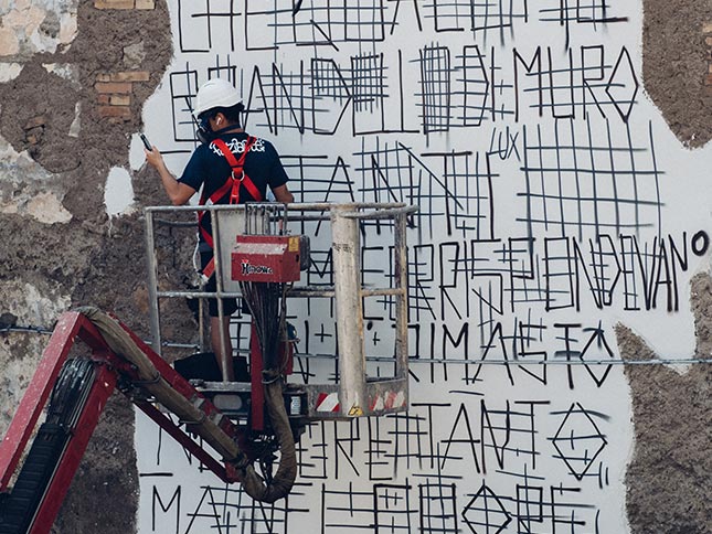 Faziarte bemalt die vom Krieg zerstörte Mauer und erstellt eine grobe Skizze