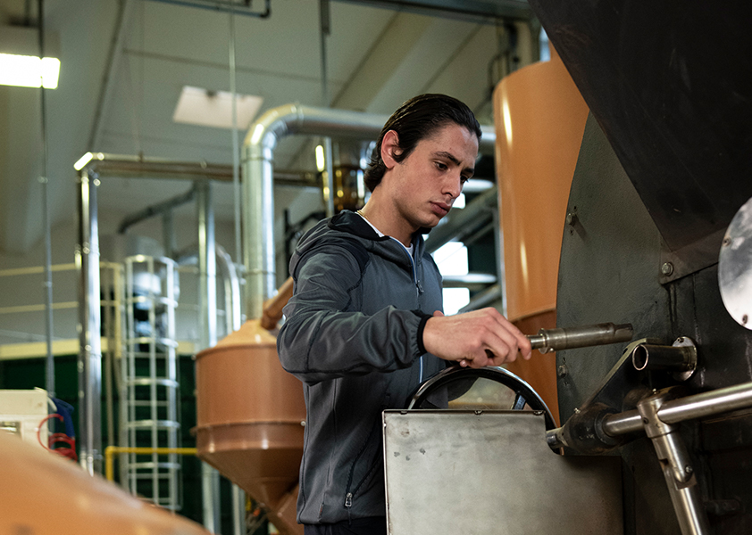 Produkttechniker Leone kontrolliert regelmäßig den Röstvorgang der Bohnen Master Leone trägt bei der Arbeit die bequeme und leichte Fleecejacke Stretch Evolution